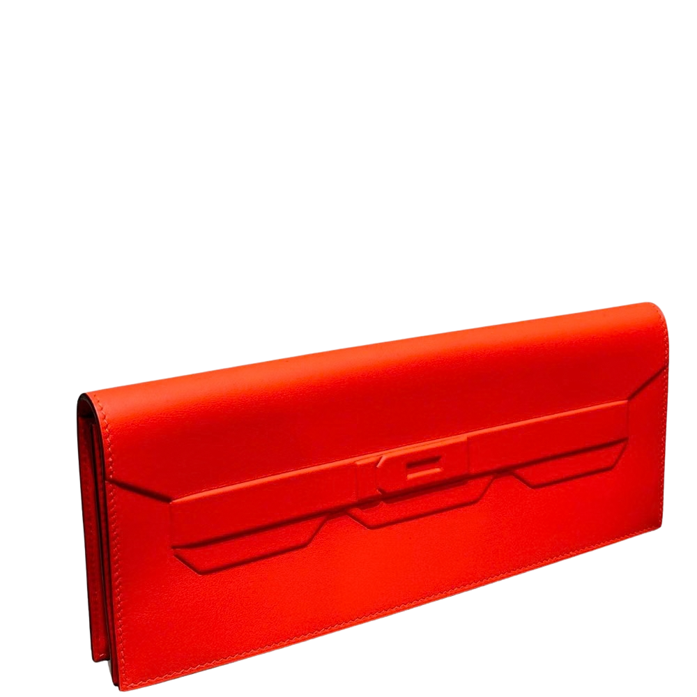 Hermes Kelly Pochette Shadow Orange Swift left side profile, displaying the slender structural gusset and sleek silhouette.
