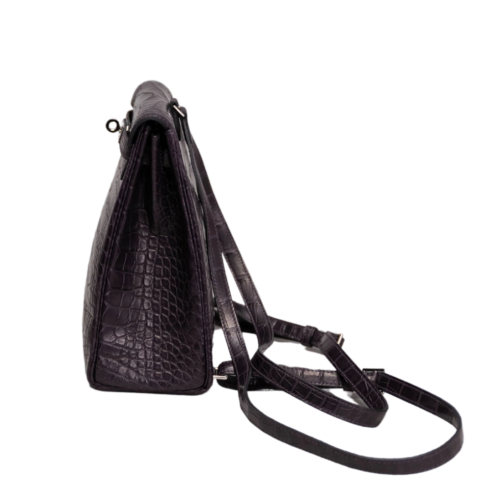 Side view of Hermès Kelly Ado backpack in matte alligator leather with silver hardware
